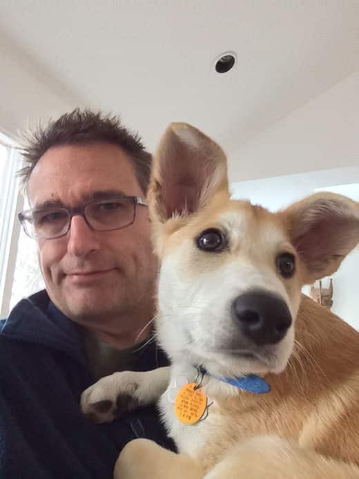 Dog in blue collar taking selfie with a man in glasses Dog taking a selfie with pet parent
